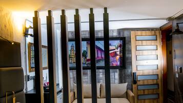 A modern room with a sofa, a television, and a wooden partition.