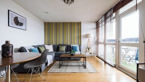 Una sala de estar moderna con un sofá, una mesa de centro y un ventanal con persianas.