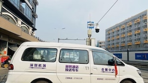 A white van parked on a street with signage indicating it is a shuttle service for a hotel. - Lavande Hotel (Shenzhen Airport Fuyong Metro Station) (Shenzhen)