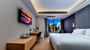 A modern hotel room with a bed, desk, and a city view. - Lavande Hotel (Shenzhen Airport Fuyong Metro Station) (Shenzhen)