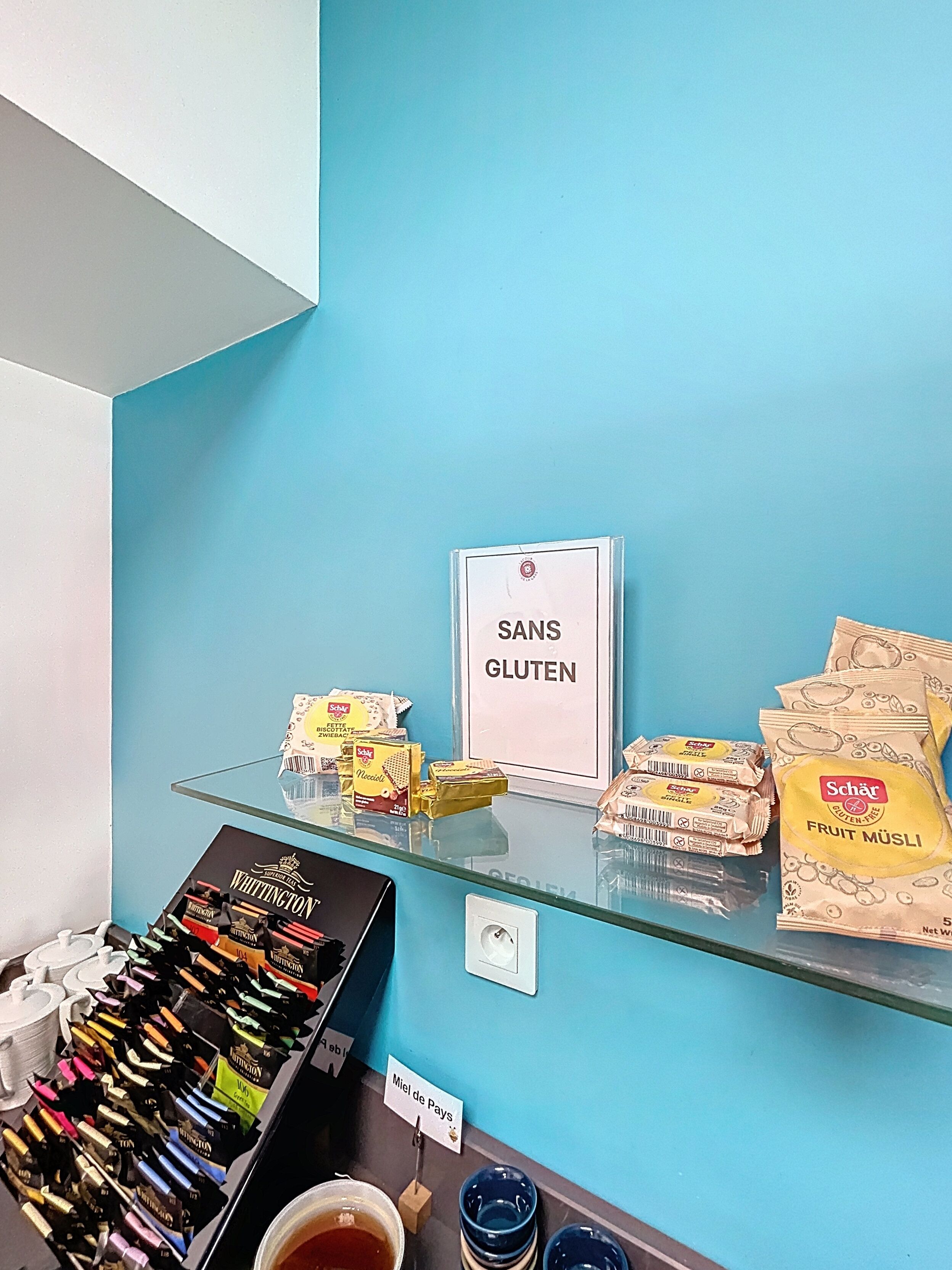 Een etalage met snacks, waaronder glutenvrije opties en verschillende soorten chocolade.