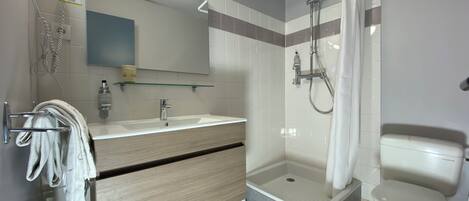 A modern bathroom with a shower, toilet, and vanity.