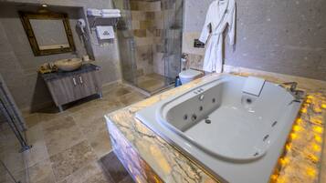 Un baño moderno con una bañera grande, una ducha con cerramiento de vidrio y un tocador de mármol.