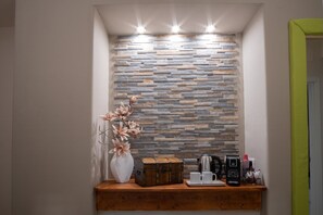 Cozy corner with stone wall feature, wooden shelf, and comfortable seating area.