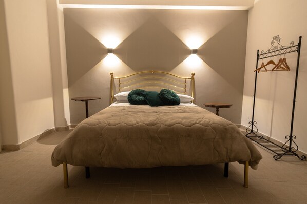 Cozy retreat with a large bed, bedside tables, and a stylish metal rack for your belongings.