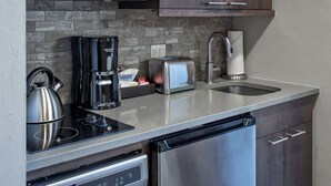 Uma cozinha moderna com eletrodomésticos de aço inoxidável, cafeteira, torradeira e máquina de lavar louça.