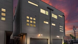 Ein modernes, zweistöckiges Gebäude mit flachem Dach, großen Fenstern und einer Garage.