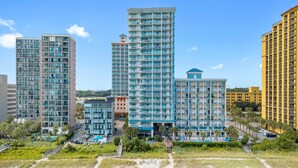A modern hotel complex with multiple high-rise buildings, a central courtyard, and a beach area. - Rent the best! Oceanfront! Gorgeous remodel! 3 bedrooms 3 baths! Views! Views! (Myrtle Beach)