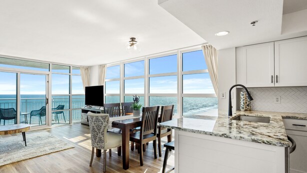 A modern kitchen with a large island, white cabinets, and a view of the ocean. - Rent the best! Oceanfront! Gorgeous remodel! 3 bedrooms 3 baths! Views! Views! (Myrtle Beach)