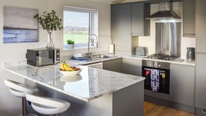 A modern kitchen with a large island, stainless steel appliances, and a view of the outdoors. - 3 bedroom accommodation in Barrow, near Clitheroe (Barrow, near Clitheroe)
