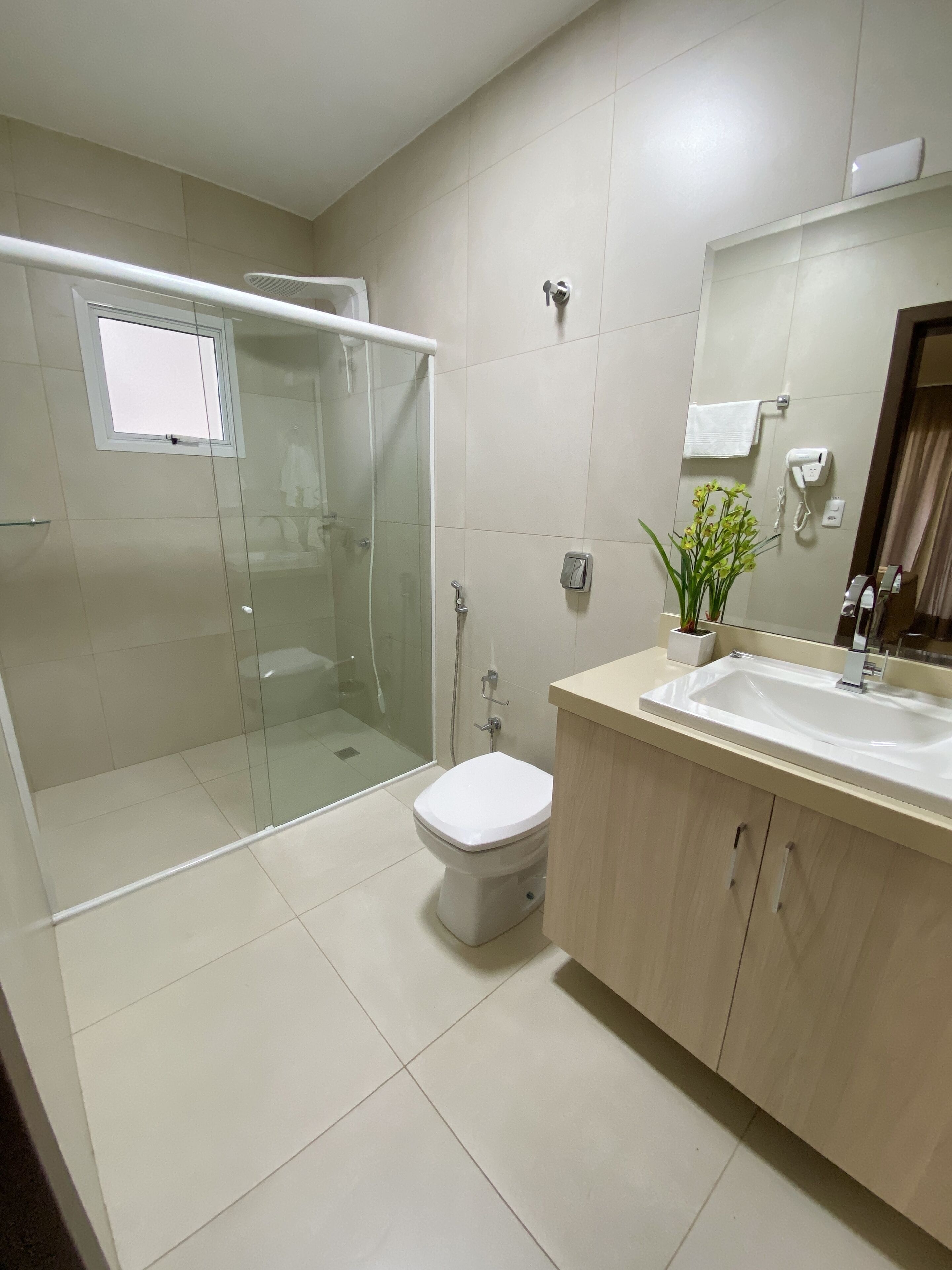 deluxe apartment | bathroom | shower, hair dryer, towels, toilet paper