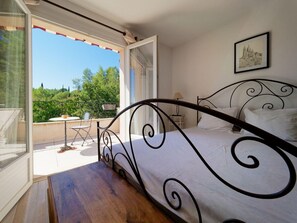 Relax in a serene bedroom with a comfortable bed and a sliding door leading to an outdoor space.