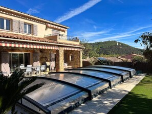 Experience the charm of this traditional two-story building, featuring a spacious outdoor area with a swimming pool and seating arrangements.