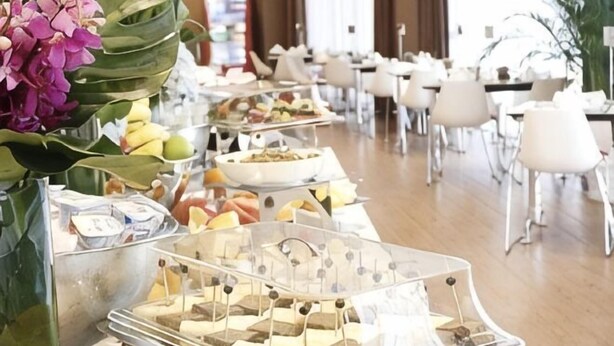 A buffet setup with various food items and a decorative orchid. - Haitao Hotel (Zhaoqing Seven Star Rock Archway Scenic Spot) (Zhaoqing)