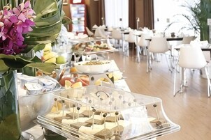 Montaje tipo bufé con diferentes alimentos y una orquídea decorativa.