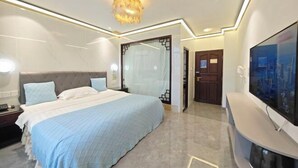 A modern hotel room with a large bed, a TV, a chandelier, and a glass partition. - Haitao Hotel (Zhaoqing Seven Star Rock Archway Scenic Spot) (Zhaoqing)