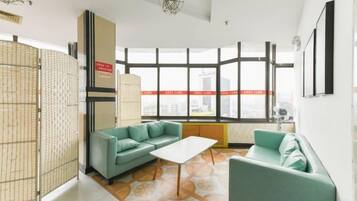 Una sala de estar moderna con un ventanal grande, un sofá, una mesa de centro y un separador decorativo.