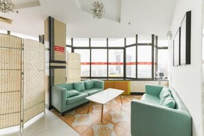 Una sala de estar moderna con un ventanal grande, un sofá, una mesa de centro y un separador decorativo.