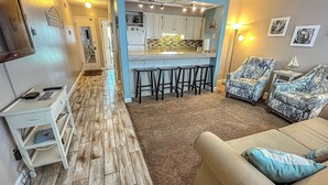 A compact living space with a kitchenette, a sofa, and a bar stool area. - Relaxing 1Br Condo sleeps 4.  Pool outside back door.  Beach Access.   (Panama City Beach)