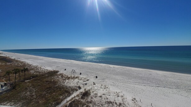 A beach with a clear sky and sunlight reflecting on the water. - Relaxing 1Br Condo sleeps 4.  Pool outside back door.  Beach Access.   (Panama City Beach)