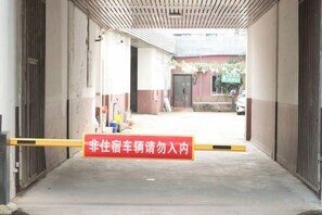 A gated entrance to a building with a red sign in a foreign language.