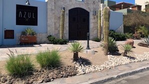A building with a stone facade, a black door, and a sign that reads "AZUL".