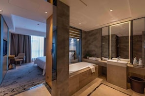 Ein modernes Hotelbad mit einer Badewanne, einem großen Spiegel und einem Waschbecken.