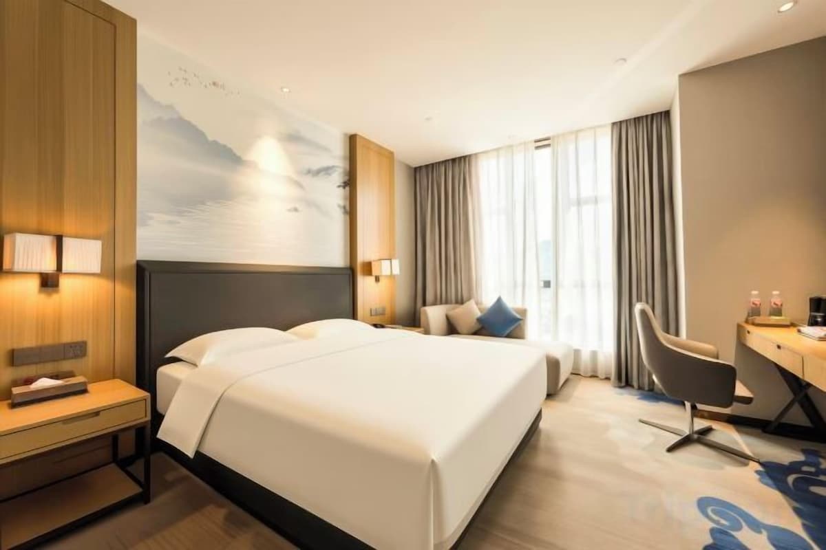 Ein Hotelzimmer mit einem großen Bett, einem Schreibtisch und einem Stuhl.