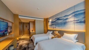 A hotel room with two beds, a TV, and a large painting on the wall. - Zhanpeng International Hotel (Chongzuo)