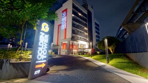 A modern building with a sign indicating 'Golden Tower Express' and a directional arrow. - Golden Tower Express Berrini by Fenix Hoteis (São Paulo)