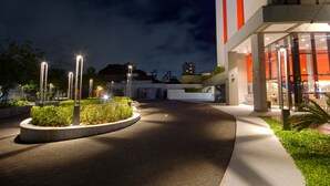 A well-lit pedestrian walkway leading to a building with a large sign. - Golden Tower Express Berrini by Fenix Hoteis (São Paulo)