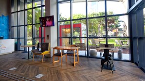 A modern indoor space with large windows, wooden furniture, and a view of the outdoors. - Golden Tower Express Berrini by Fenix Hoteis (São Paulo)