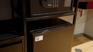 A compact refrigerator with a digital lock and a small freezer compartment.
