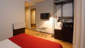 A hotel room with a bed, a TV, a wardrobe, and a small table. - Golden Tower Express Berrini by Fenix Hoteis (São Paulo)