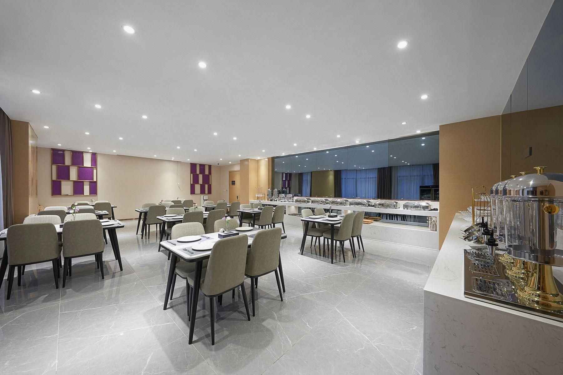 A modern dining area with multiple tables and chairs, a buffet counter, and a decorative glass sculpture.