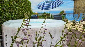 A hot tub surrounded by greenery, a pool, and a view of the sea. - Beautiful home in Lovran with WiFi (Lovran)