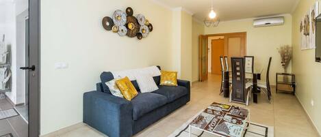A living room with a sofa, a coffee table, and a decorative wall piece.
