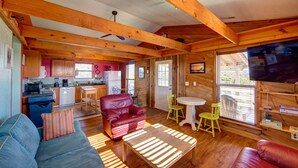A cozy cabin interior with a kitchen, dining area, and seating space. - Surf Chalet w/ hot tub and kayaks (Avon)