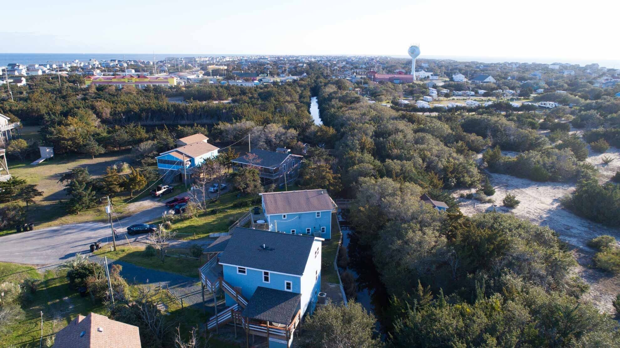 A residential area with houses, a road, and a water tower in the distance.