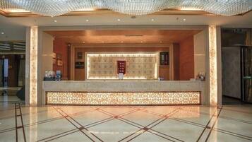 A reception area with a tiled floor, a reception desk, and a decorative ceiling.