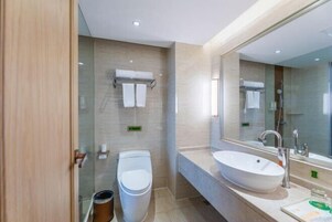 Un baño moderno con un lavamanos grande, un inodoro y una cabina de ducha de vidrio.