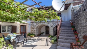 A courtyard with a pergola, outdoor seating, a stone staircase, and a satellite dish. - Awesome home in Grizane (Grizane)