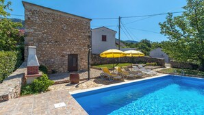 A stone building with a pool, yellow umbrellas, and lounge chairs. - Awesome home in Grizane (Grizane)