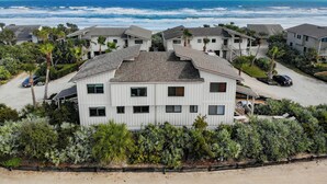 Ein Küstenwohngebiet mit mehreren zweigeschossigen Häusern, jedes mit einem Balkon und Blick aufs Meer.