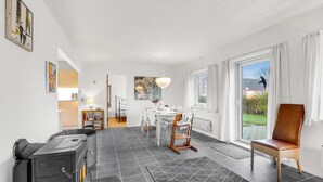 Un vaste espace de vie comprenant une table à manger, une cheminée et une vue sur l’extérieur.