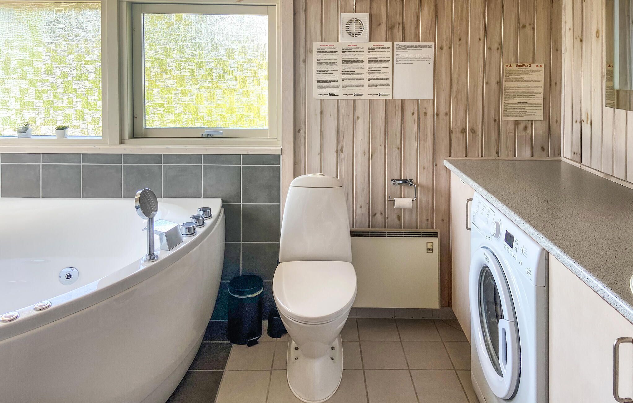 Un bagno con vasca, WC e lavatrice.