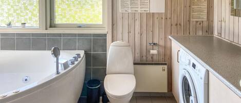 Un bagno con vasca, WC e lavatrice.