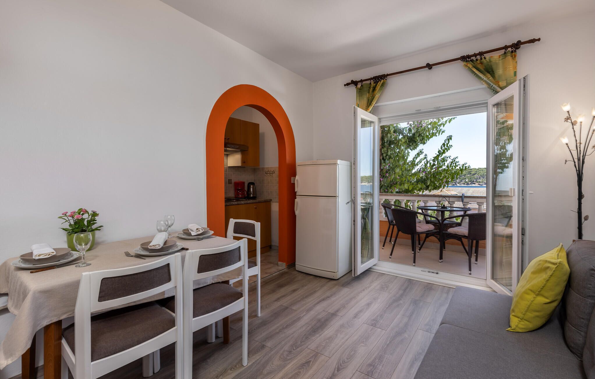 A compact kitchen with a refrigerator, a dining table with chairs, and a small dining set.