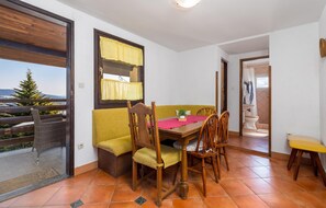 A dining area with a wooden table, yellow chairs, and a yellow sofa. - Stunning home in Vrbovsko (Vrbovsko)