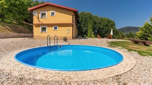 A swimming pool with a house in the background.